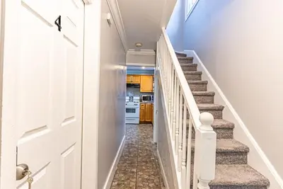 a hallway with a staircase leading to a kitchen at Private BR Trains EWR USA Mall Penn Station in Newark