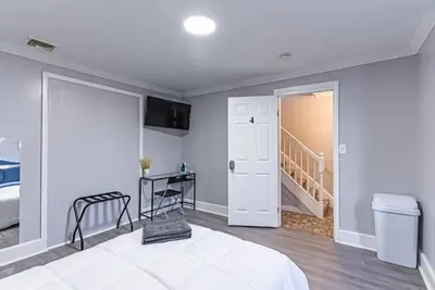 a bedroom with a white bed and a staircase at Private BR Trains EWR USA Mall Penn Station in Newark