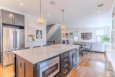 an open kitchen with a large island in the middle at Bergen County NYC Bus Malls in Maywood