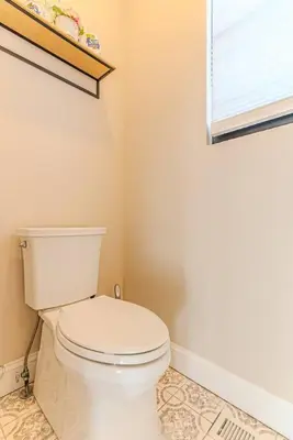 a bathroom with a white toilet and a window at Bergen County NYC Bus Malls in Maywood
