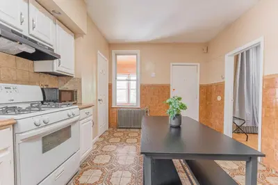 a kitchen with white appliances and a black table at NYC Train EWR Liberty Park 1 in Bayonne