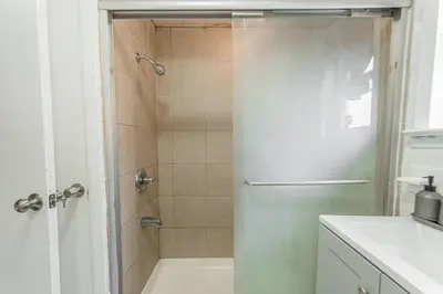a shower with a glass door in a bathroom at NYC Train EWR Liberty Park 1 in Bayonne