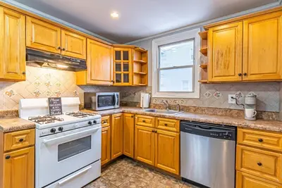 a kitchen with wooden cabinets and a white stove top oven at Private BR Trains EWR USA Mall Penn Station in Newark