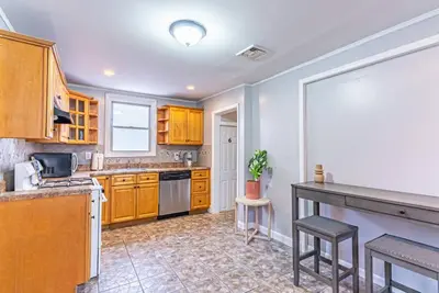 a kitchen with wooden cabinets and a counter top at Private BR Trains EWR USA Mall Penn Station in Newark