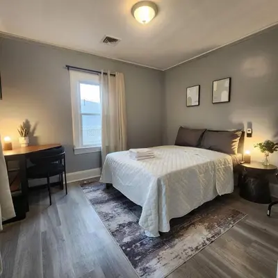 a bedroom with a bed and a desk and a window at Private Bedroom w Shared Space A in South Hackensack