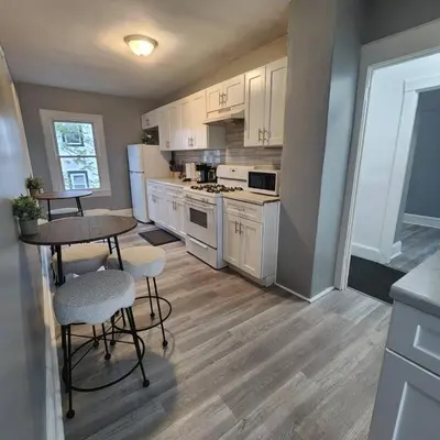 a kitchen with white appliances and a table and chairs at Private Bedroom w Shared Space A in South Hackensack