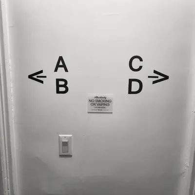 a sign on a wall with arrows on it at Private Bedroom w Shared Space A in South Hackensack