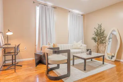 a living room with a couch and a table at Bunk Room Walk 2 Train Shops in Bayonne