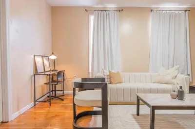 a living room with a white couch and a table at NYC Train EWR Liberty Park 2 in Bayonne