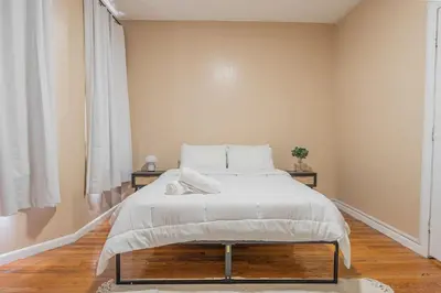 a bedroom with a large bed with white blankets and pillows at Roomy 4br Walk to Transit connect to NYC in Bayonne