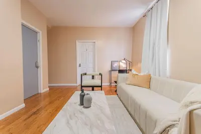 a living room with a white couch and a chair at Roomy 4br Walk to Transit connect to NYC in Bayonne