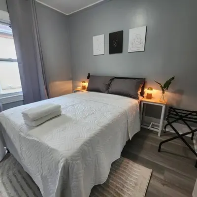 a bedroom with a large white bed with two lamps at Bus Train 2 NYC Spacious 4BR SH in South Hackensack