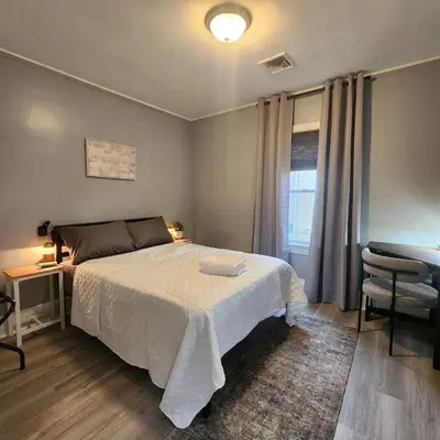a bedroom with a bed and a chair and a window at Bus Train 2 NYC Spacious 4BR SH in South Hackensack