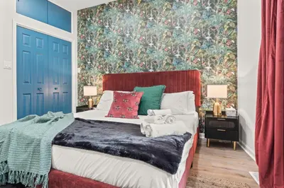 a bedroom with a bed with a large painting on the wall at Stylish 1BR 1,5BA Old City Condo Near Liberty Bell in Philadelphia
