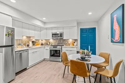 a kitchen with white cabinets and a table and chairs at Stylish 1BR 1,5BA Old City Condo Near Liberty Bell in Philadelphia