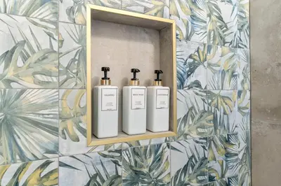 three white bottles on a wall with a mirror at Stylish 1BR 1,5BA Old City Condo Near Liberty Bell in Philadelphia