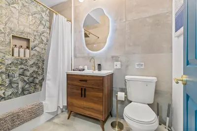 a bathroom with a toilet and a sink and a mirror at Stylish 1BR 1,5BA Old City Condo Near Liberty Bell in Philadelphia