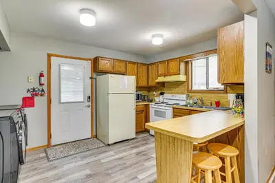 a kitchen with wooden cabinets and a white refrigerator at Home with Fire Pit in Jim Thorpe 6 Mi to Dtwn! in Jim Thorpe