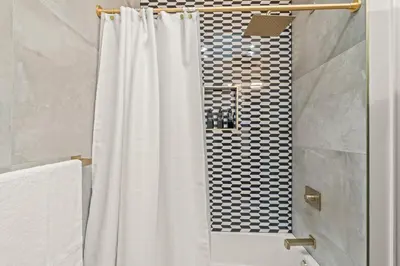 a shower with a white shower curtain in a bathroom at Historic Old City 1BR 1BA Near Independence Hall in Philadelphia