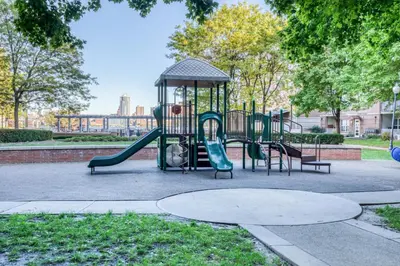 a playground with a slide in a park at Blueground Hudson Exchange pool nr Liberty Park NYC-1800 in New York
