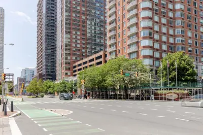 an empty street in a city with tall buildings at Blueground Hudson Exchange pool nr Liberty Park NYC-1800 in New York