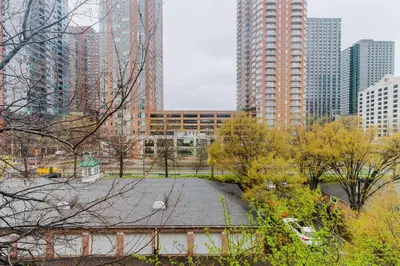 a park in the middle of a city with tall buildings at Blueground Hudson Exchange pool nr Liberty Park NYC-1800 in New York