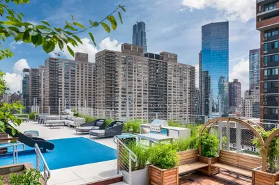 a rooftop patio with a pool and a city skyline at Blueground Lincoln Square rooftop nr Central Park NYC-1217 in New York