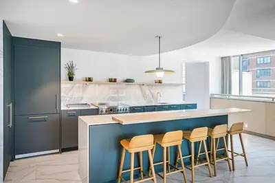 a kitchen with a counter with stools around it at Blueground Lincoln Square rooftop nr Central Park NYC-1217 in New York