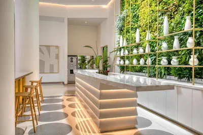 a kitchen with a green wall with plants at Blueground Lincoln Square rooftop nr Central Park NYC-1217 in New York