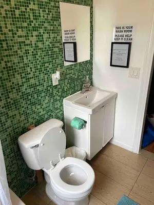 a bathroom with a white toilet and a sink at Hudson Guest House in Jersey City