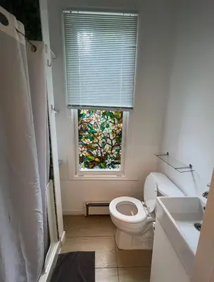 a bathroom with a toilet and a window at Hudson Guest House in Jersey City