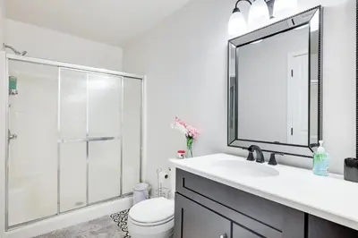 a bathroom with a toilet and a sink and a mirror at Hot Tub & Theater Haven-Lake and Ski Retreat in Blakeslee