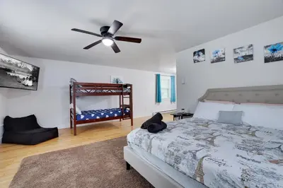 a bedroom with a bed and a ceiling fan at Hot Tub & Theater Haven-Lake and Ski Retreat in Blakeslee