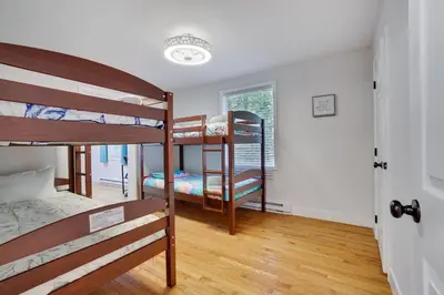 a dorm room with three bunk beds in it at Hot Tub & Theater Haven-Lake and Ski Retreat in Blakeslee