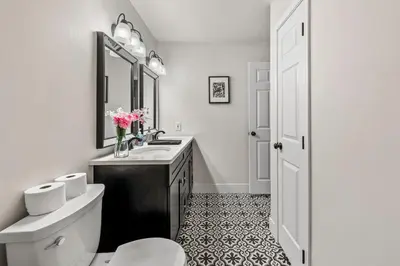 a bathroom with a sink and a toilet and a mirror at Hot Tub & Theater Haven-Lake and Ski Retreat in Blakeslee