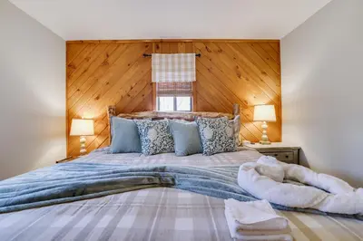 a bedroom with a large bed with a wooden headboard at Moose Tracks Cabin Hot Tub 5 Min to Slopes in Lake Harmony