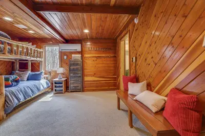 a bedroom with a bed and a wooden wall at Moose Tracks Cabin Hot Tub 5 Min to Slopes in Lake Harmony