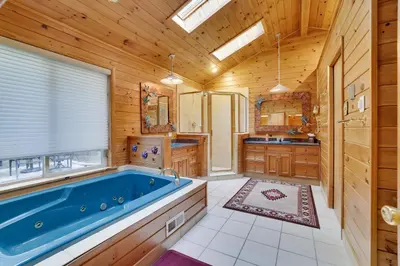 a bathroom with a large blue tub in a room at Arrowhead Lodge Walk to Lake & Private Dock in Pocono Lake