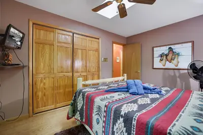 a bedroom with a bed and a wooden closet at Arrowhead Lodge Walk to Lake & Private Dock in Pocono Lake