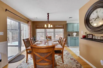 a dining room with a table and a clock on the wall at Lakeside Escape at StillwaterHot Tub & Ski in Pocono Summit