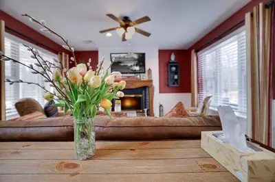 a vase of flowers on a table in a living room at Lakeside Escape at StillwaterHot Tub & Ski in Pocono Summit