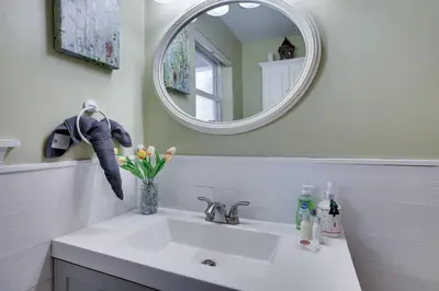 a bathroom with a white sink and a mirror at Lakeside Escape at StillwaterHot Tub & Ski in Pocono Summit