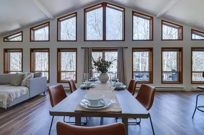 a dining room with a table and chairs and windows at Serene Escape at Big Bass Lake & Pool Access in Clifton