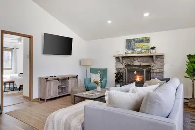 a living room with a white couch and a fireplace at Serene Escape at Big Bass Lake & Pool Access in Clifton