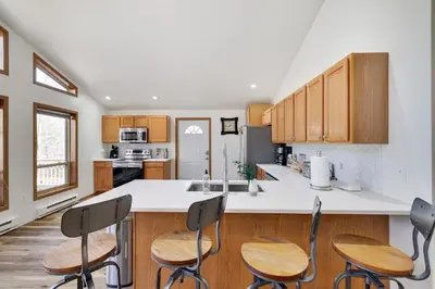 a kitchen with wooden cabinets and a white counter top at Serene Escape at Big Bass Lake & Pool Access in Clifton