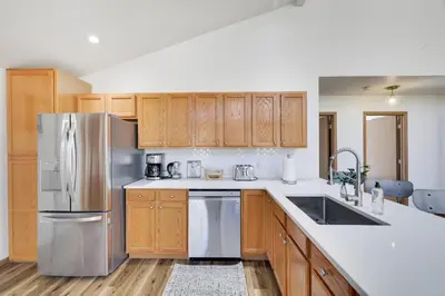 a kitchen with wooden cabinets and a stainless steel refrigerator at Serene Escape at Big Bass Lake & Pool Access in Clifton
