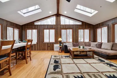a living room with a couch and a table at Bear Haven Cabin - Epic Game RoomLakeFire Pit in Gouldsboro