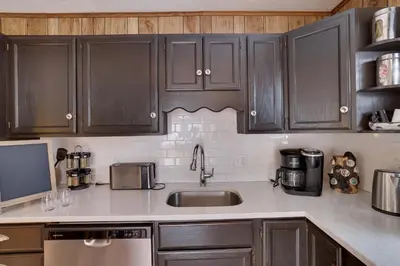 a kitchen with wooden cabinets and a sink at Bear Haven Cabin - Epic Game RoomLakeFire Pit in Gouldsboro
