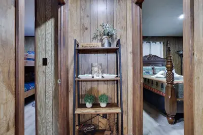 a room with wooden walls and a bedroom with bunk beds at Bear Haven Cabin - Epic Game RoomLakeFire Pit in Gouldsboro