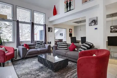 a living room with couches and red chairs at Husky Hideaway-Hot Tub, 1 Mile Lake & Ski in Lake Harmony